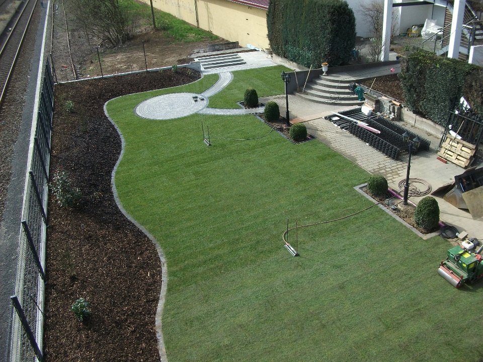 Gartenanlage mit geschwungenen Wegen und Rasen während der Ausführung